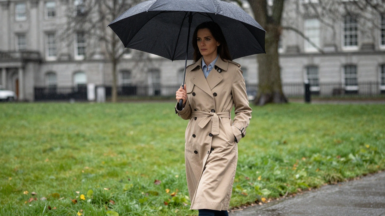 Woman in beige trench coat walking through rainy Phoenix Park